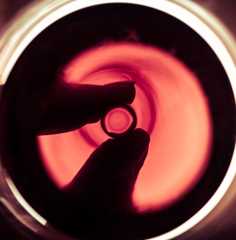 Main rétroéclairée tenant le peid d'un verre de vin