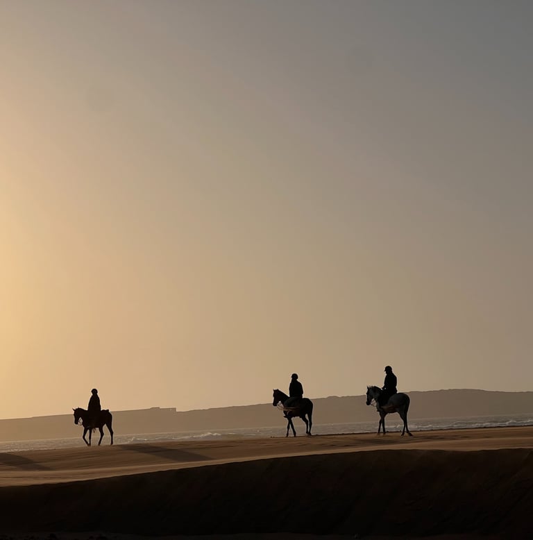 cavaliers dans les dunes au coucher de soleil