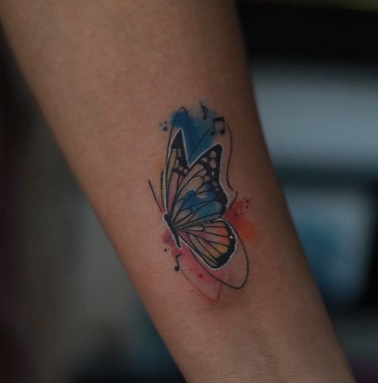 Butterfly tattoo with music notes watercolor fill on arm by Dudo’s Hyderabad