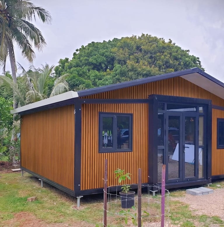 Tiny house en bois avec ossature acier et façades vitrées dans un décor tropical.