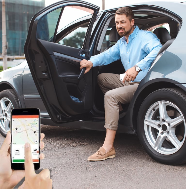 Um homem sentado em um carro com um celular na mão