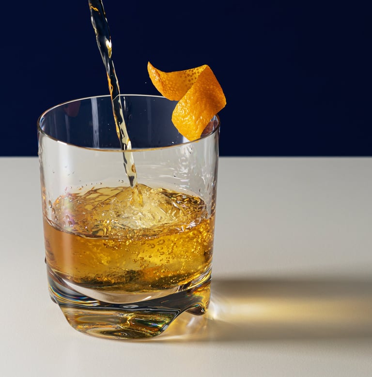 Product photography - drink being poured into a glass with an orange peel