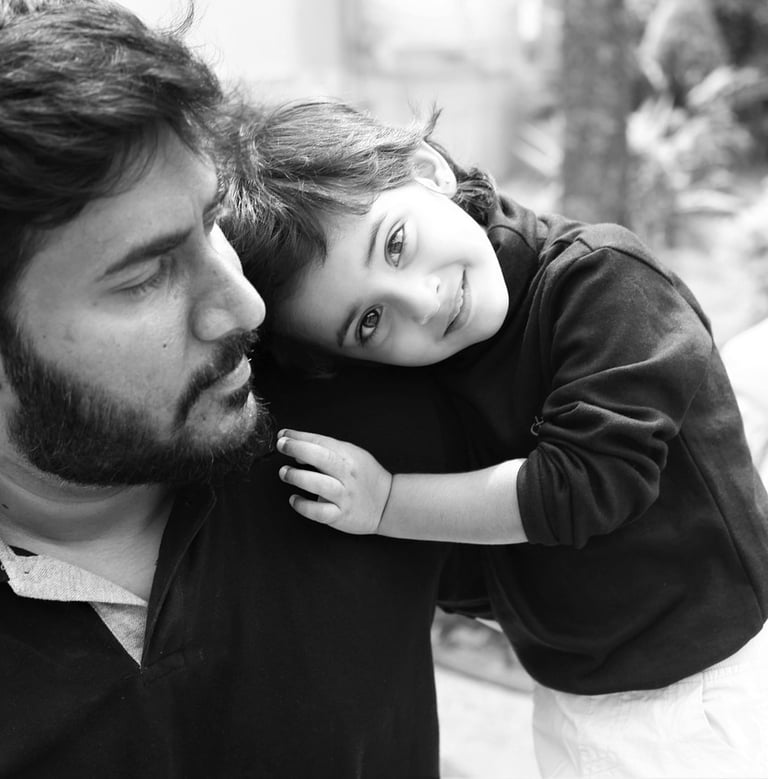 a father and his little child are smiling and hugging