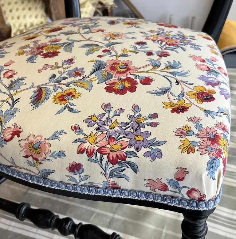 Une chaise Napoléon III avec une assise à motif floral coloré sur fond écru
