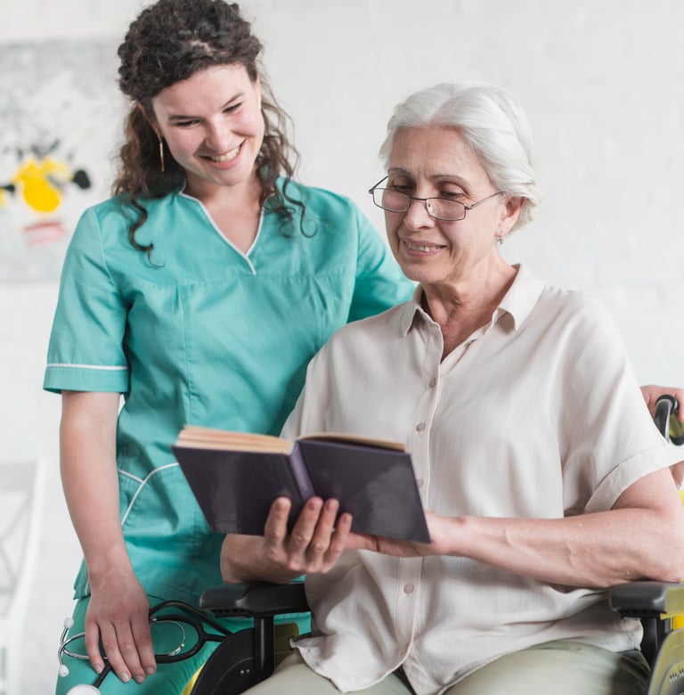 a senior woman reading a book with her caregiver