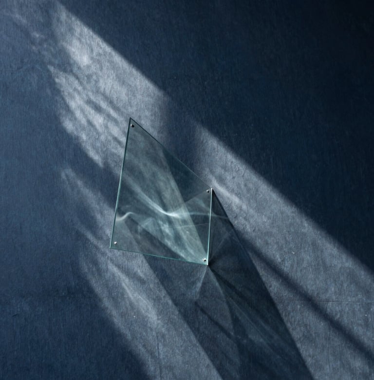 Abstract photography of light filtering through a glass installation, creating poetic shadows on a dark slate blue wall, minimalist and avant-garde style, Latinoamericano / Español context.