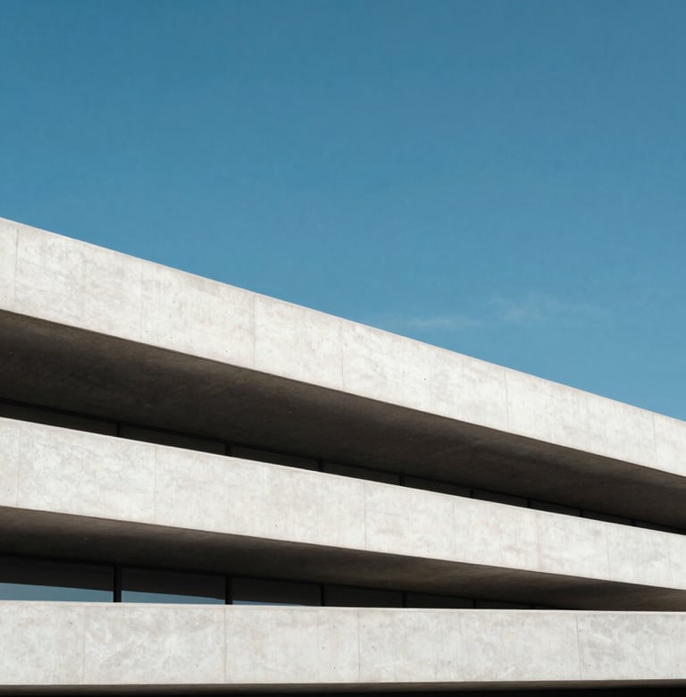 An outdoor photograph of a minimalist concrete structure in a North American city. The white concrete forms sharp horizontal lines against a vibrant cerulean blue sky. The lighting is crisp, highlighting the sophisticated and clean aesthetic of the project.