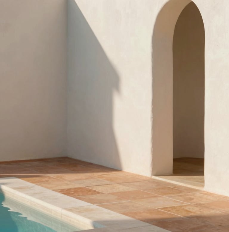 A close-up architectural detail shot of natural materials. Smooth off-white lime wash walls (#F9F6EE) meet warm terracotta floor tiles (#B85C3D) in a pool of soft afternoon sunlight.