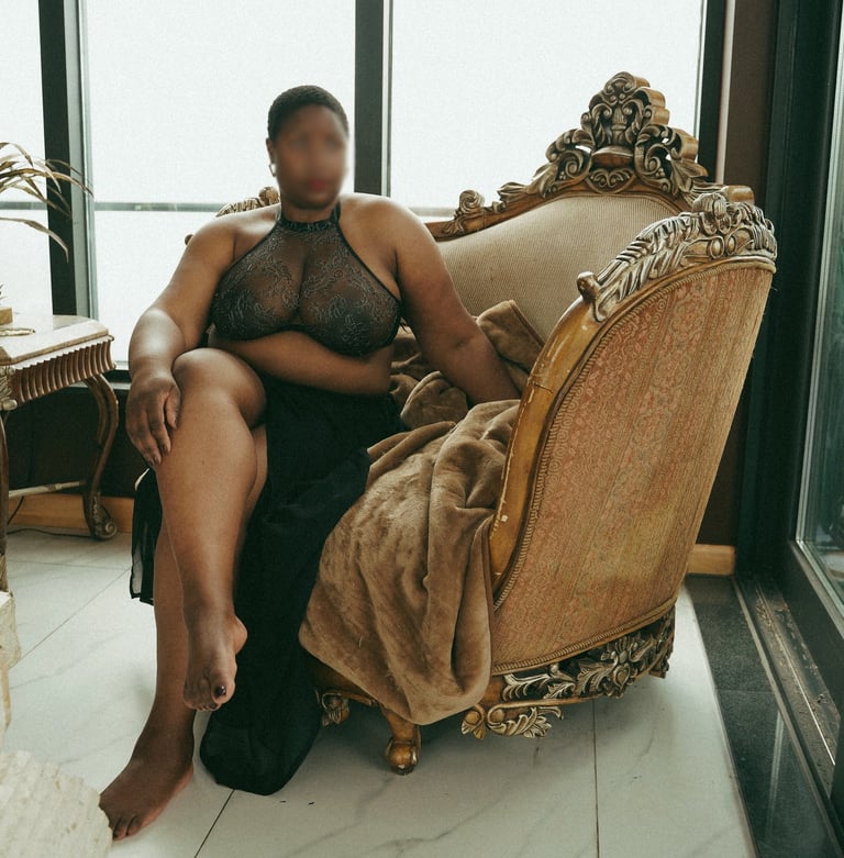Teal Revel London escort sitting in a chair