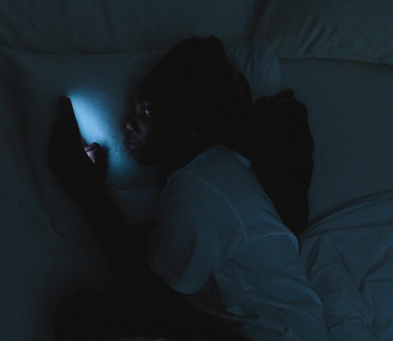 a person laying in bed with a cell phone