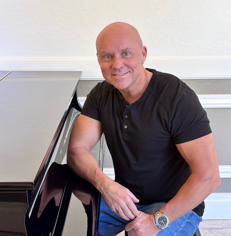 Composer Mark Bulmer sitting at the piano