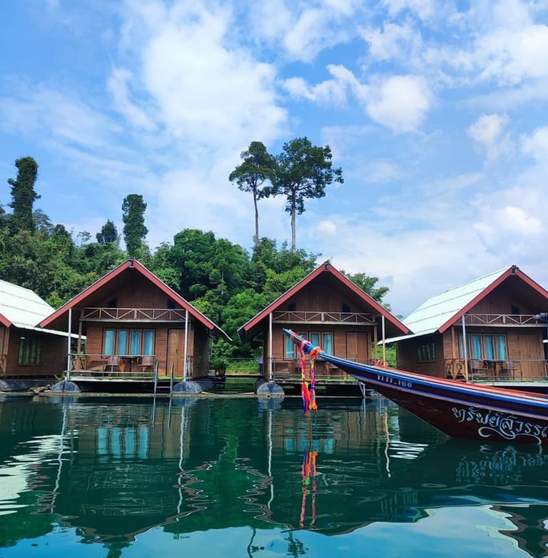  Schwimmende Holzbungalows auf dem Khao Sok See in Thailand mit einem traditionellen Langboot 