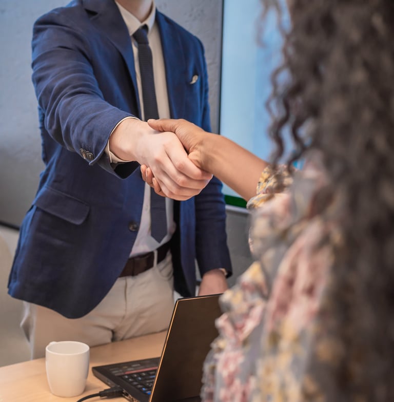 Two people shaking hands in a professional setting.