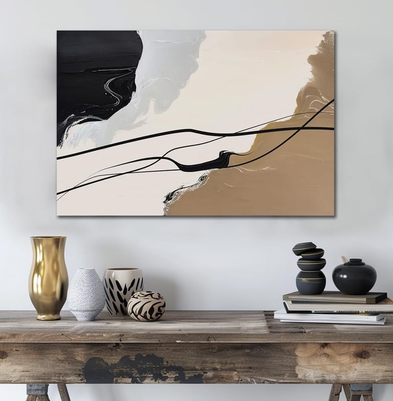 Modern abstract canvas wall art with black, beige, and gold brushstrokes hanging above a rustic wooden console table.