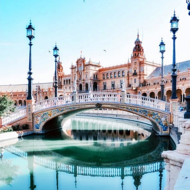 The ornate Plaza de Espana bridge and canal with historic architecture in Seville, Spain.
