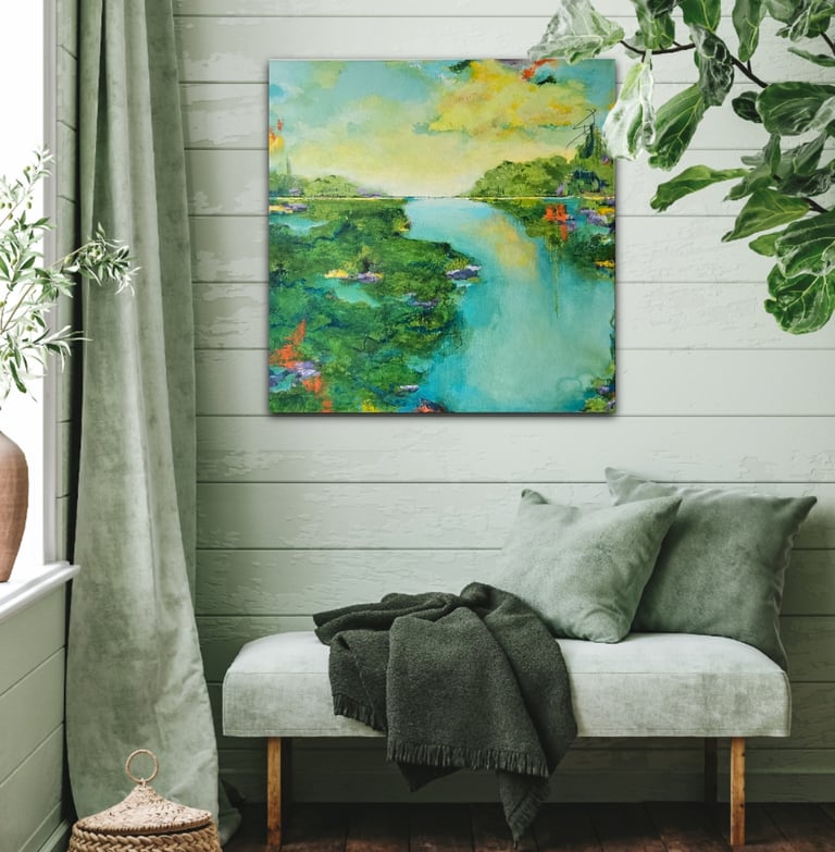 Abstract landscape painting of a blue river and green fields on a light green shiplap wall.