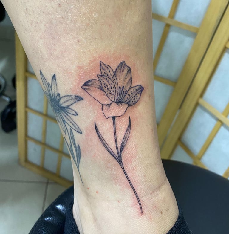 Tattoo of a flower on the ankle. Custom piece by Katarsis Tattoo Perú
