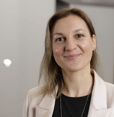a woman in a white jacket and black shirt