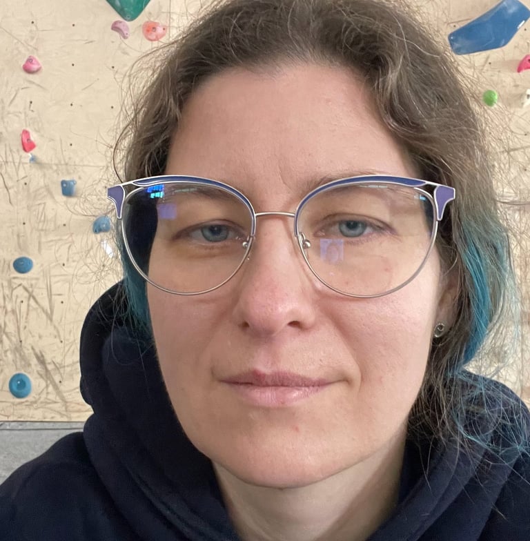 a woman with glasses and a blue hoodie