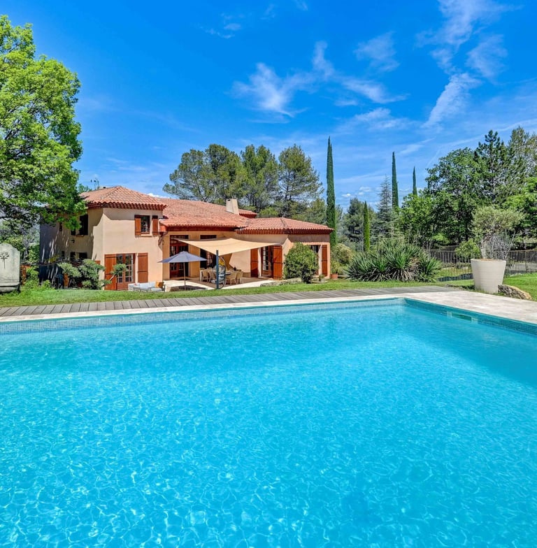 a pool with a large pool and a deck with chairs