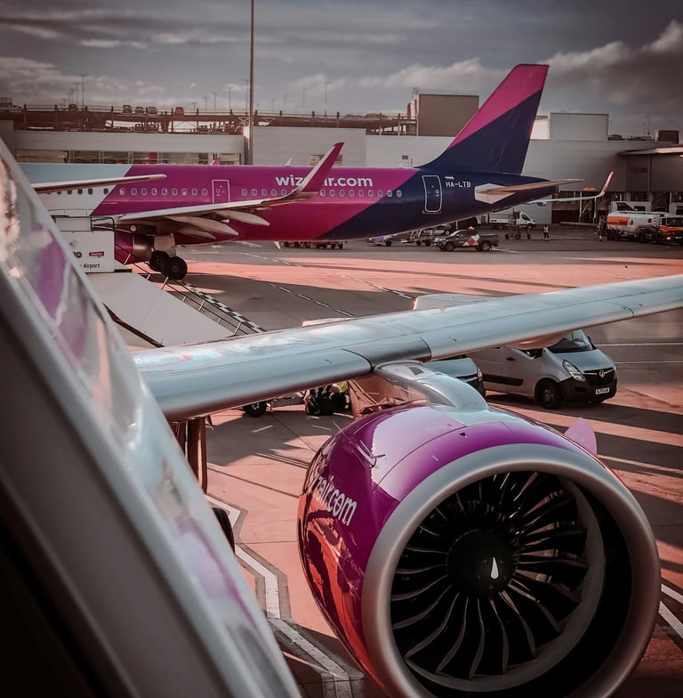Two Wizz Air aircraft parked on the airport apron beside the terminal
