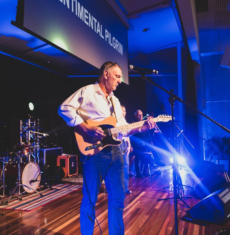 a man playing guitar in a band