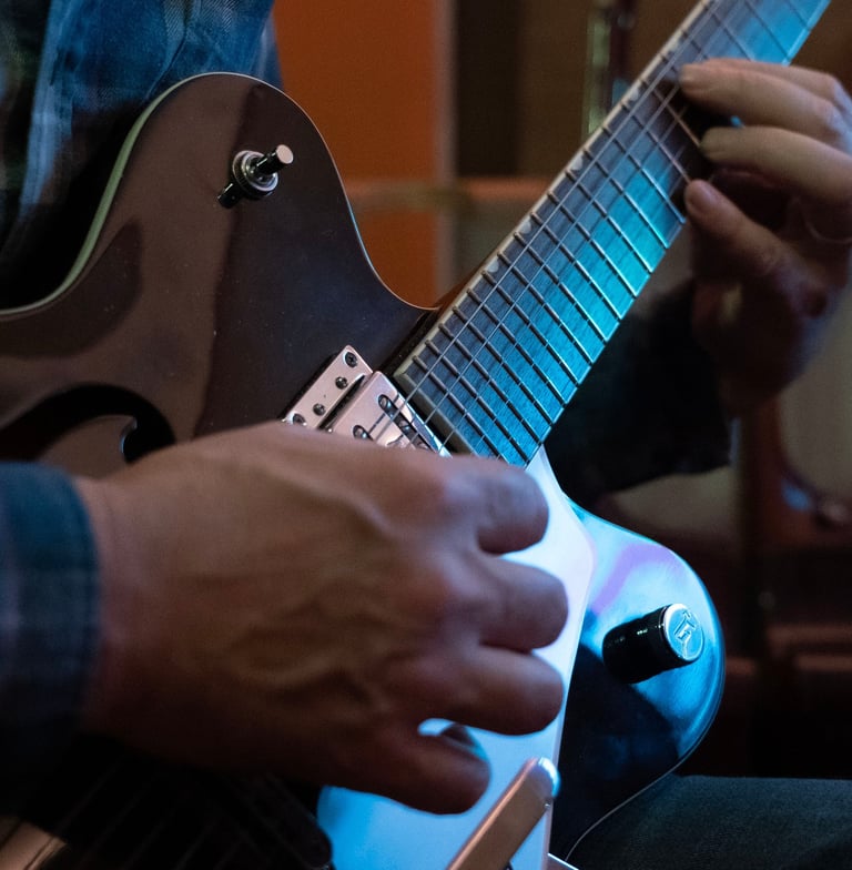 Luke Stidworthy playing guitar at Vox Music Recording Studio