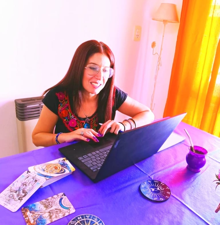 a woman sitting at a table with a laptop and a laptop