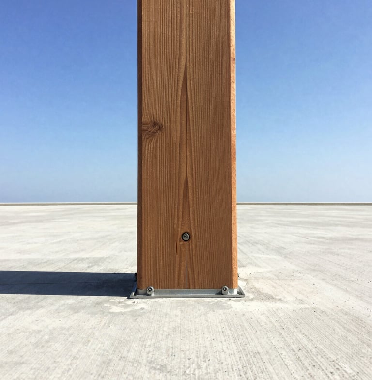 Close-up portrait shot of a heavy timber deck post anchored to a concrete footing with robust fasteners, crisp shadows, bright sunlight, wide-angle view from below.