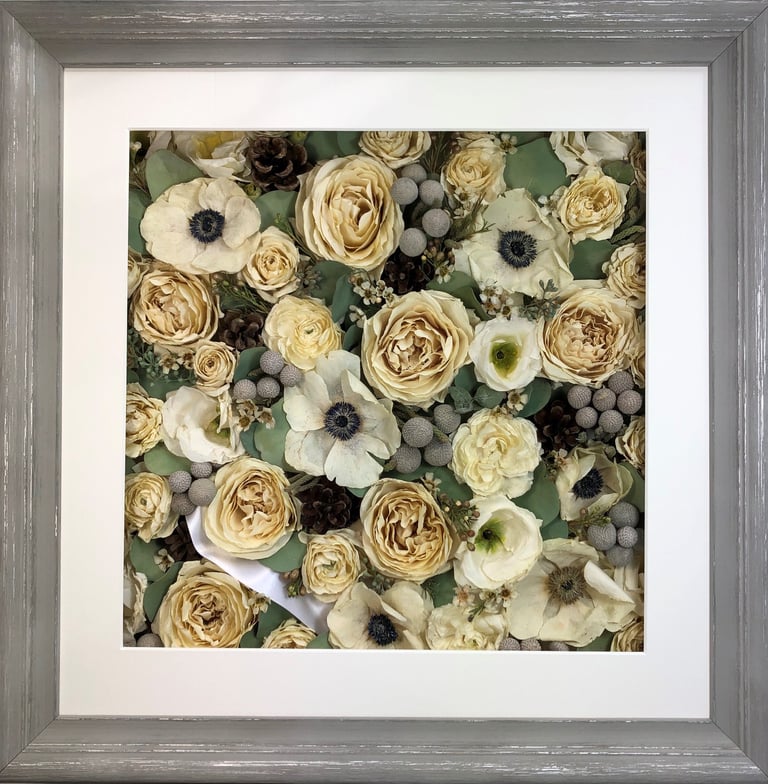 a flower wall style preserved wedding bouquet with winter berried and hidden ribbon in a frame