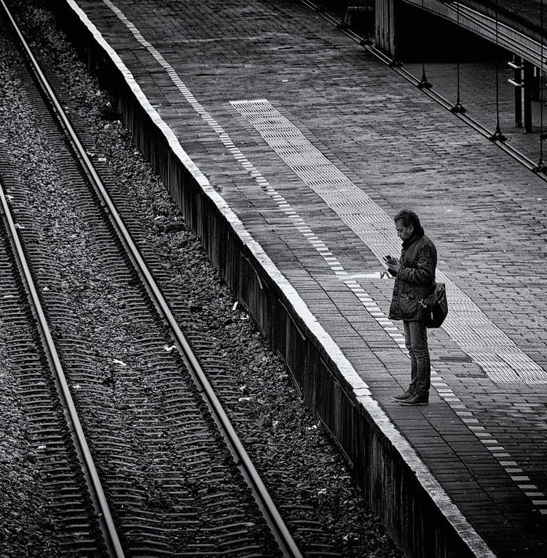 Solitary man standing on train station platform