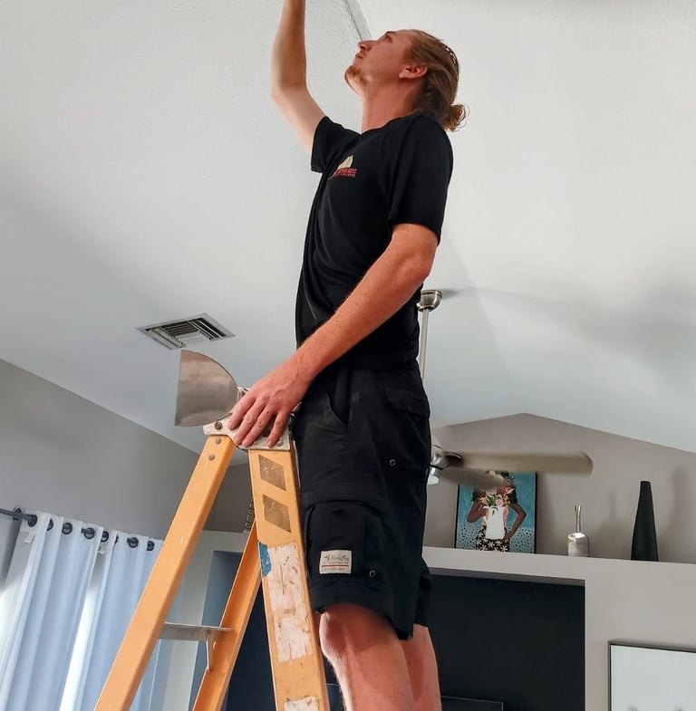 Mick is standing on a ladder doing a custom ceiling repair after water damage