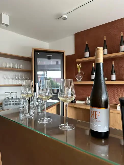 A bottle of premium Gruner Veltliner wine and glasses on a bar in Wachau Valley.