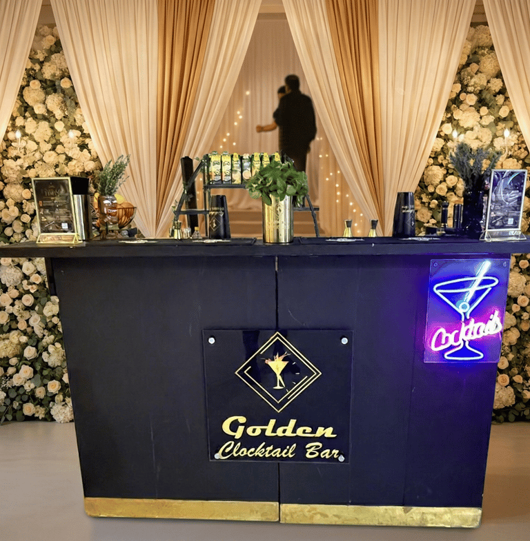 Elegant portable wedding bar with neon cocktail sign and floral backdrops for event catering.