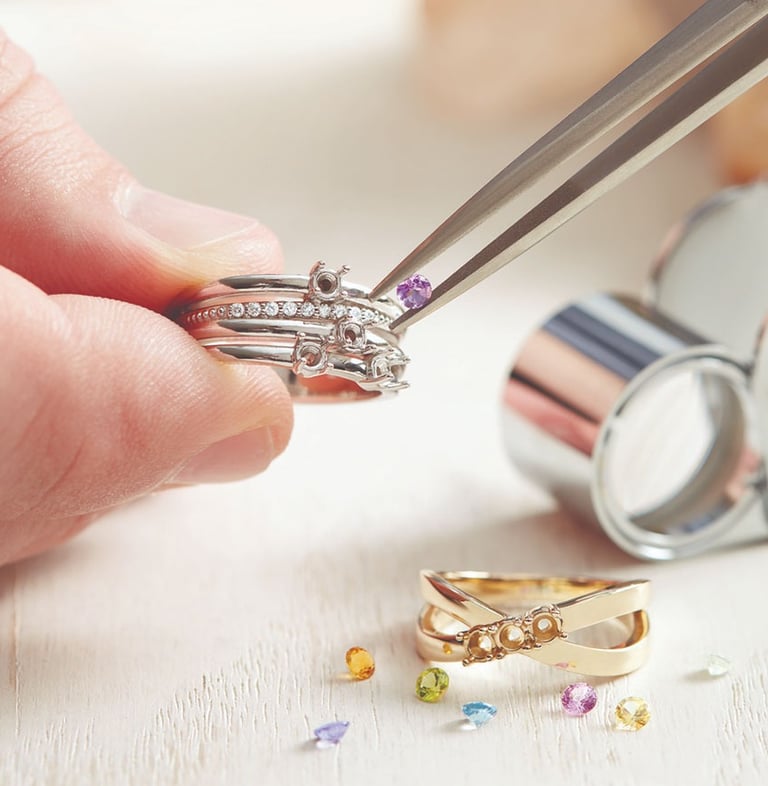 a person holding a pair of rings and a pair of scissors