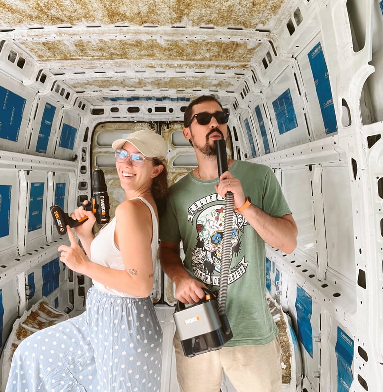 a man and woman standing in a van with power tools