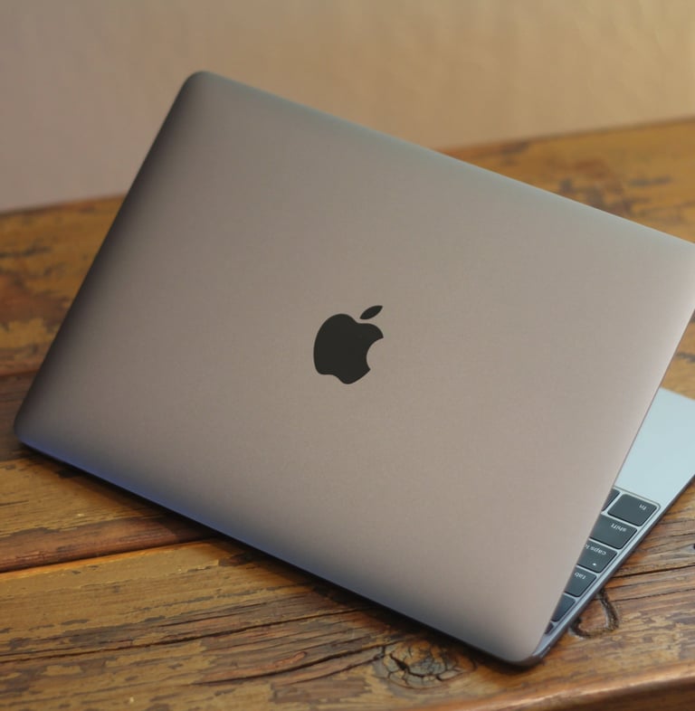 a laptop computer sitting on a wooden table