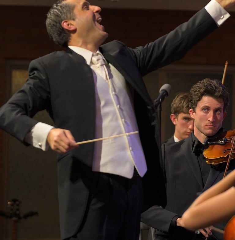 A joyful picture of Leandro conducting orchestra and choir