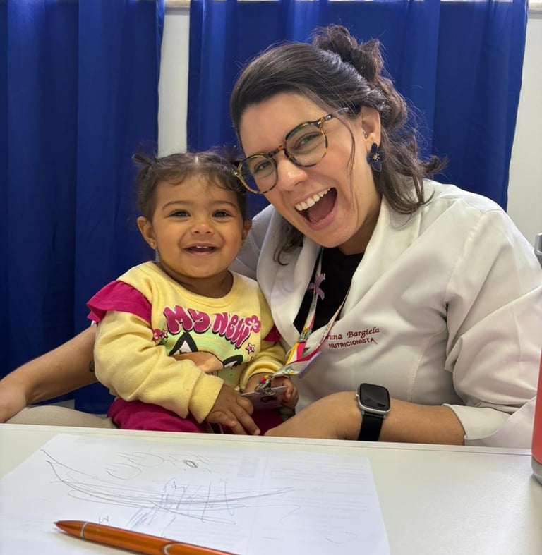 a woman in glasses and a white shirt is smiling and holding a child