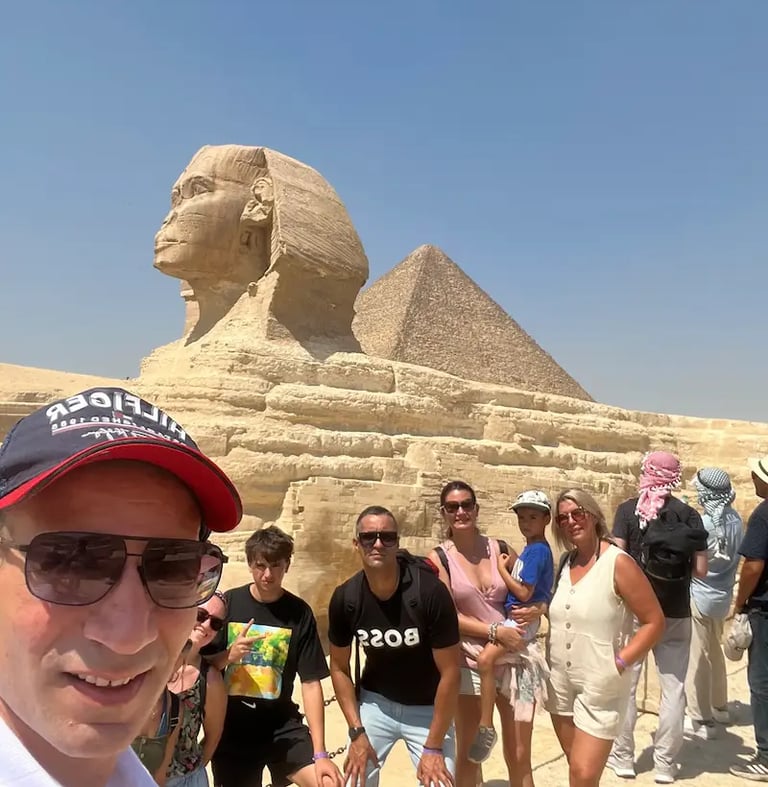 O Guia egiptologo hadi com grupo de turistas de Portugal frente da grande Esfinge.
