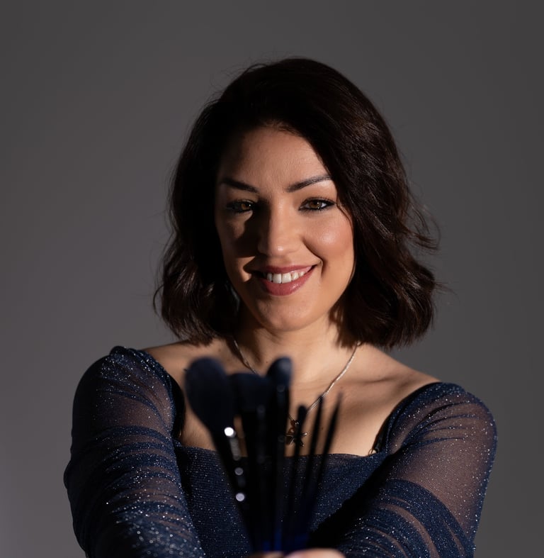 Professional makeup artist holding a set of brushes for a beauty studio portrait.