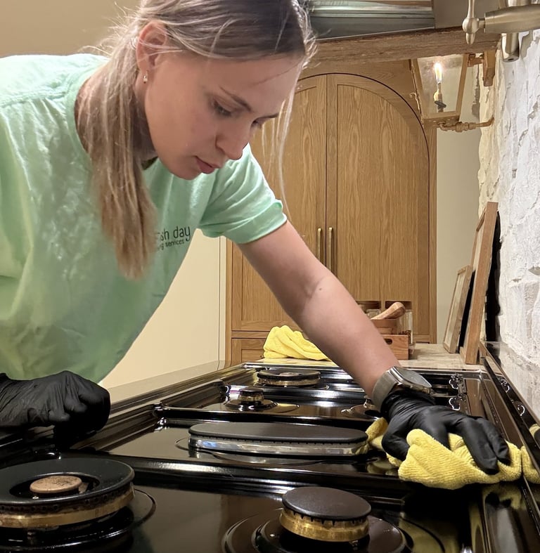 A professional cleaner expertly cleans the cooktop