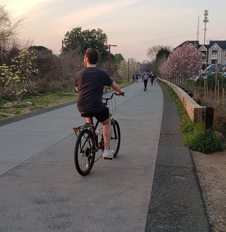 People riding bikes on a path at sunset