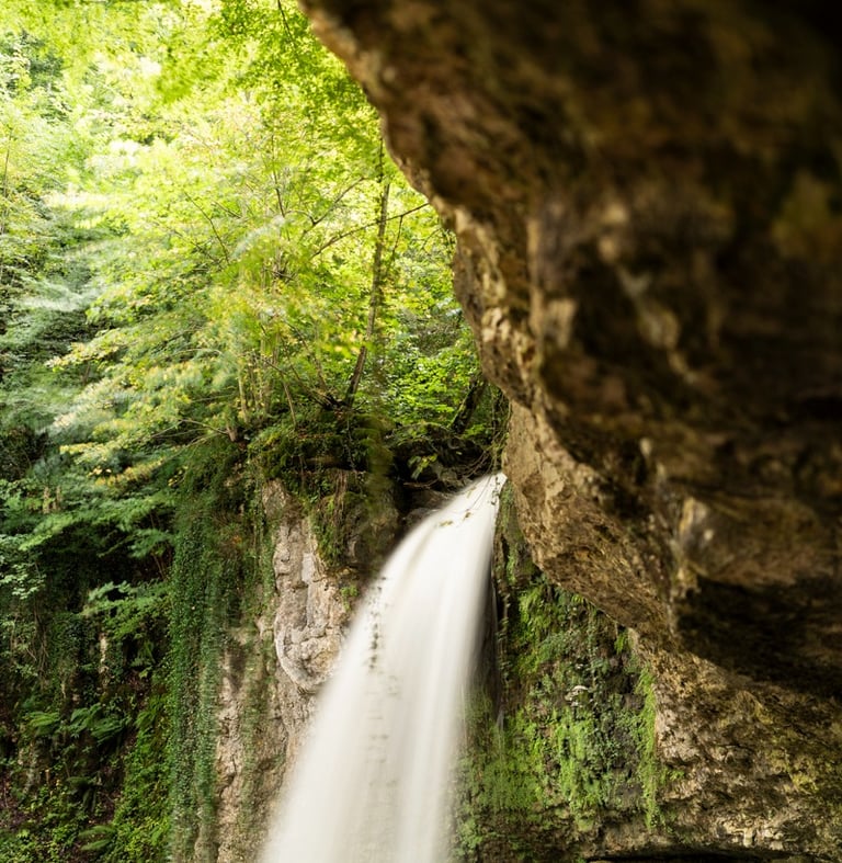 a waterfall in a cave in the woods