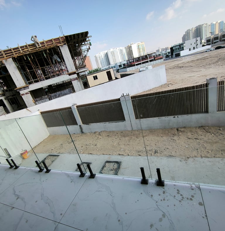 Frameless glass balcony railing with stainless steel spigot studs in Dubai.