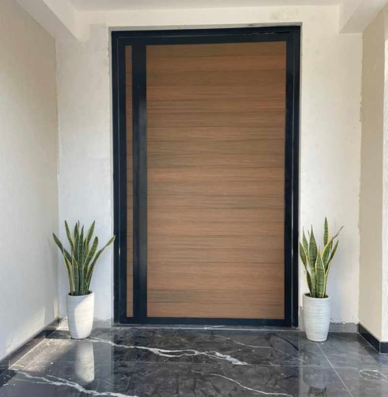 Modern villa main entrance door with wood-grain aluminum finish and black frame.