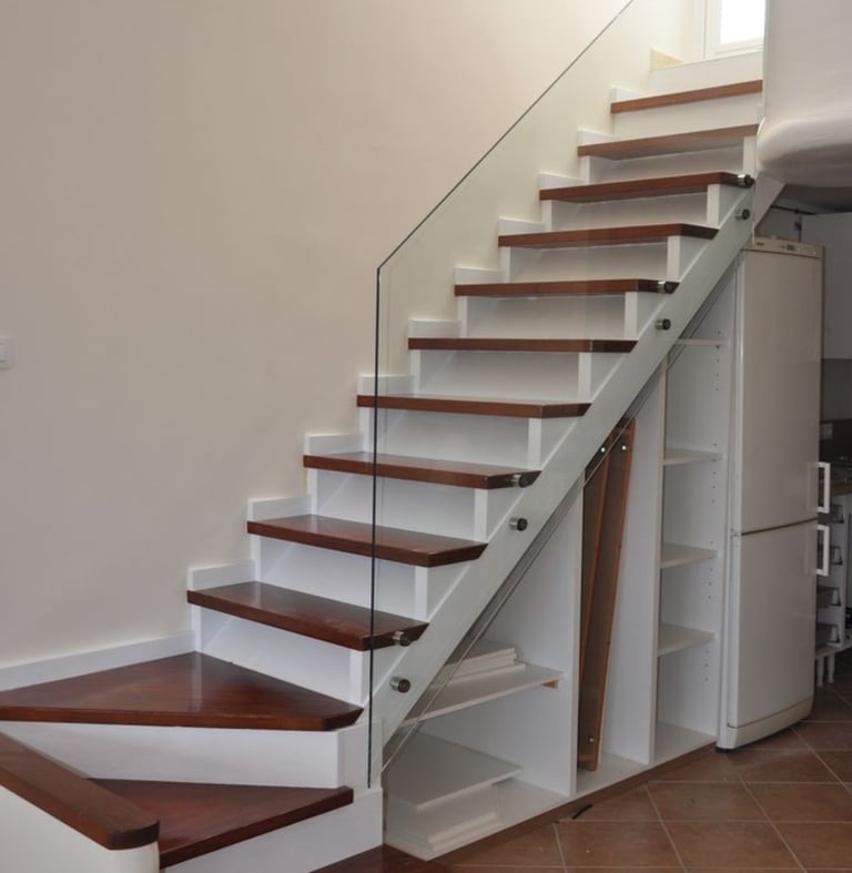 Side-mounted frameless glass stair railing with stainless steel stand-off fixings.