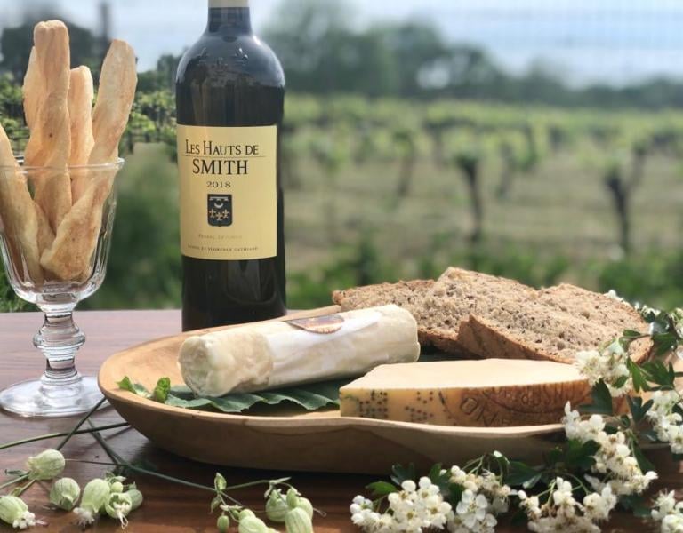 a bottle of wine and breadstickers on a table