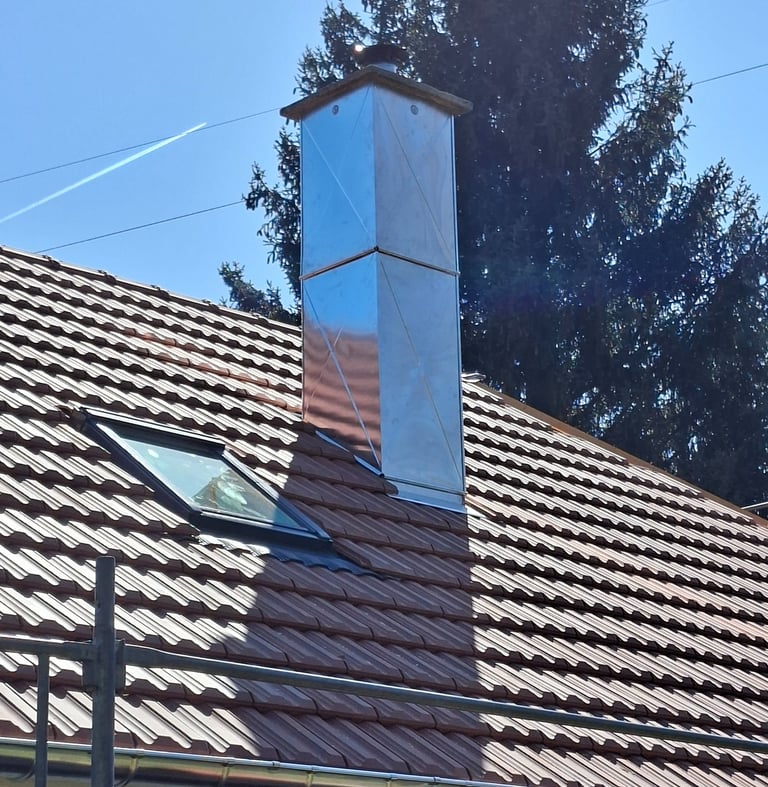 Manteau d'une grande cheminée en zinc à côté de Feche l'église.