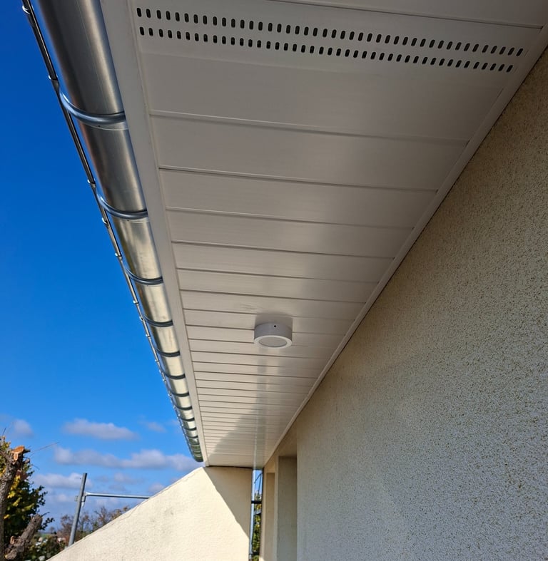 Lambris pvc blanc avec grilles de ventilation.